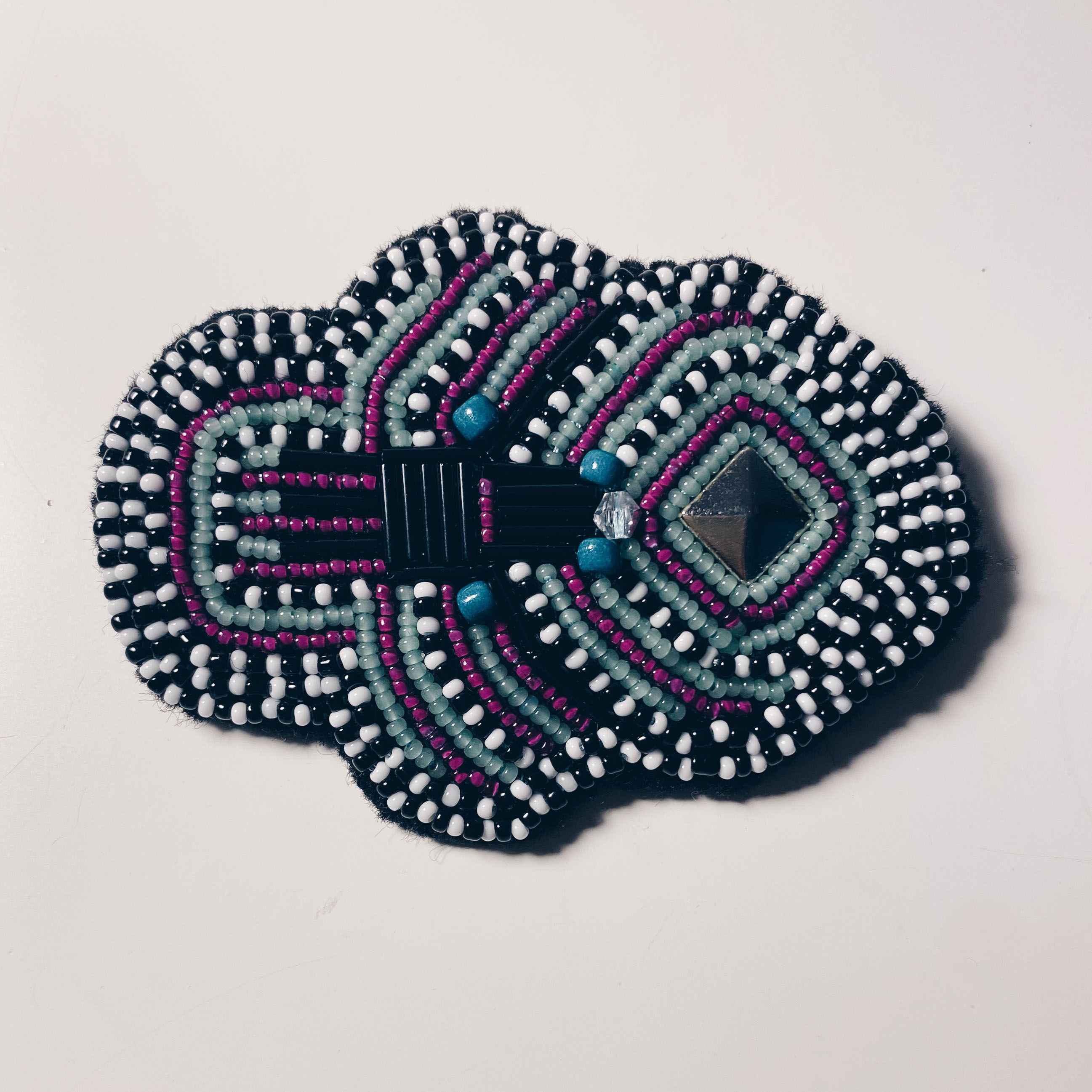 hand sewn seed beaded symmetrical black and white brooch.