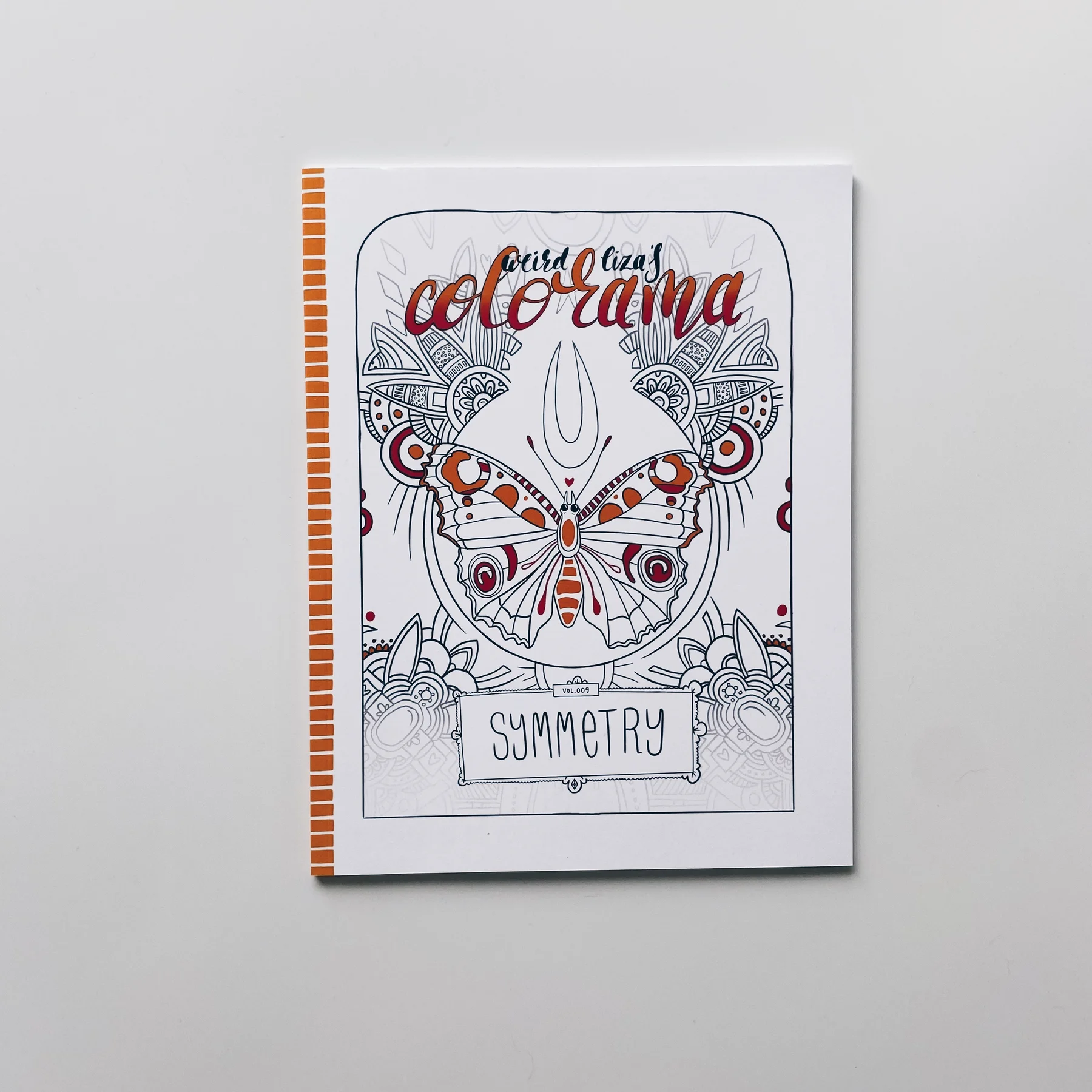 coloring book cover of weird lizas colorama volume 9 with symmetrical butterfly drawing and pattern on white background.