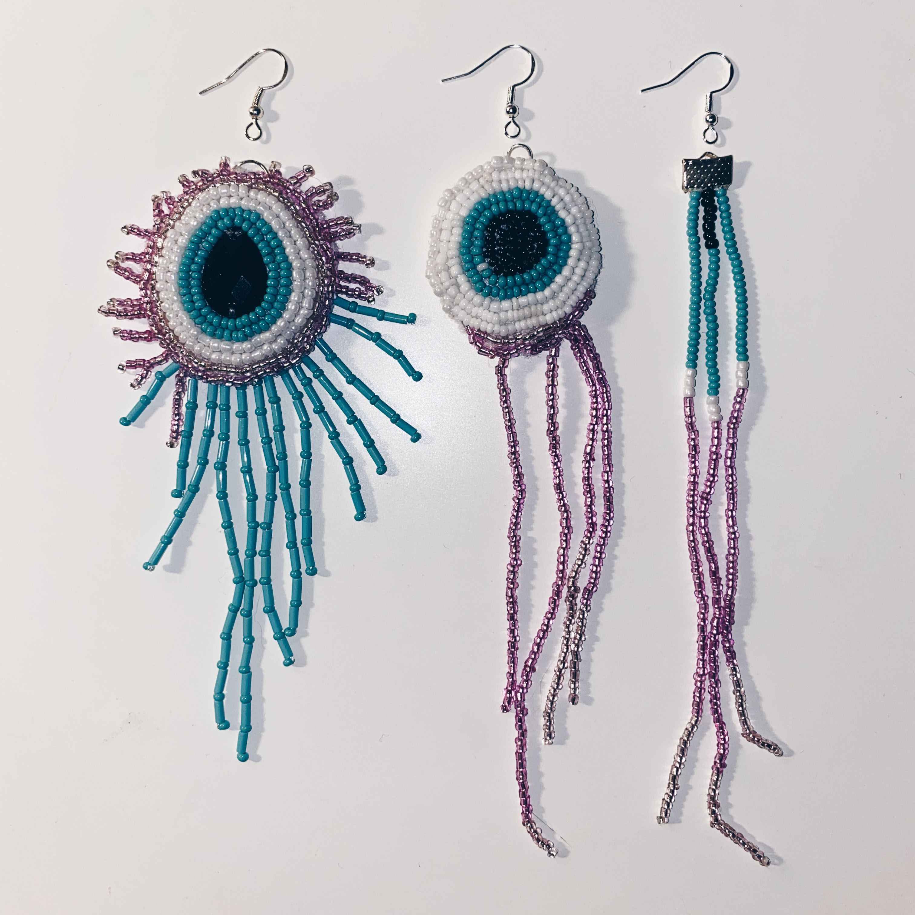 three different hand embroidered beaded earrings with teal and pink beaded tentacles hanging down.