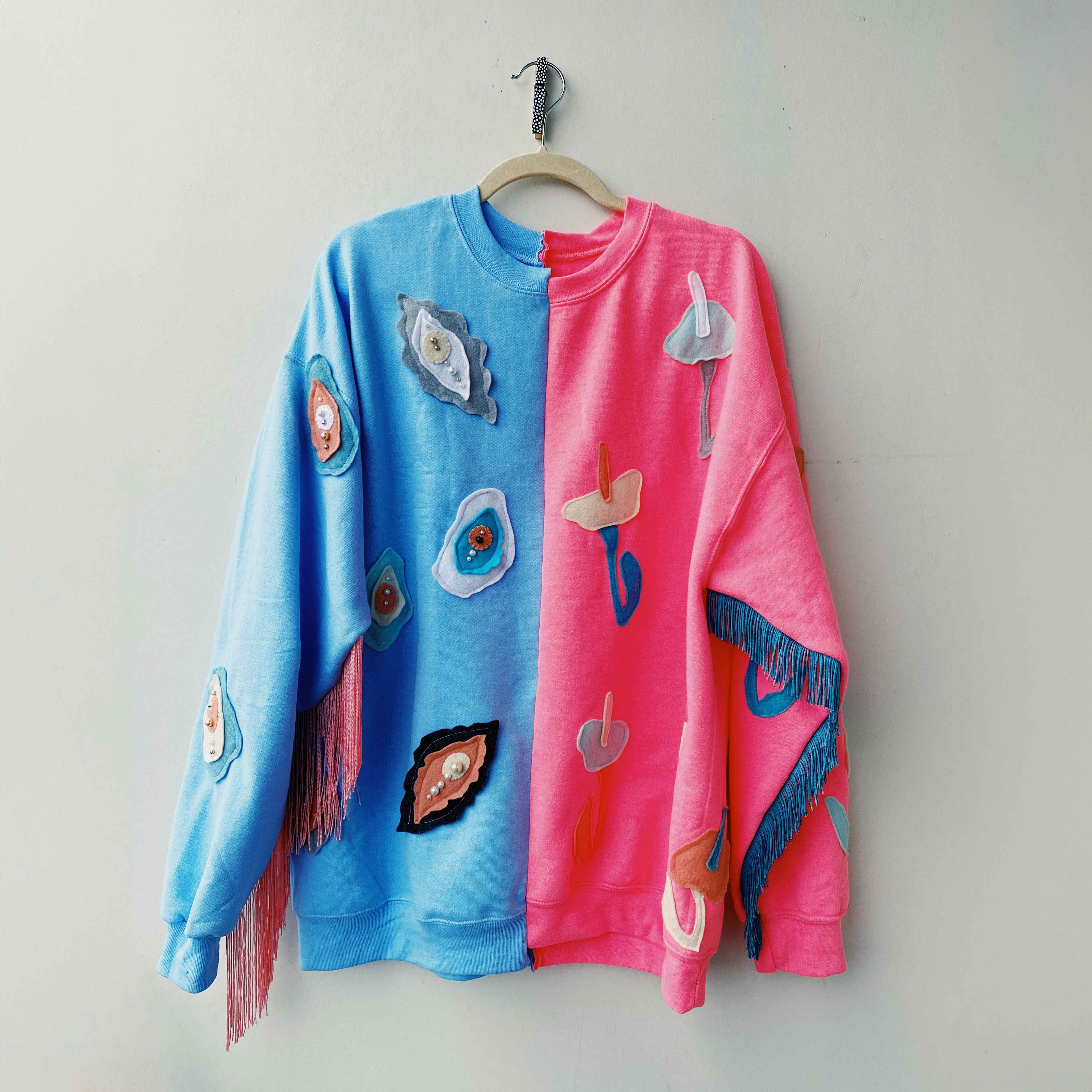 two tone sweatshirt sewn with beaded oysters and flowers and contrasting fringe on each sleeve.